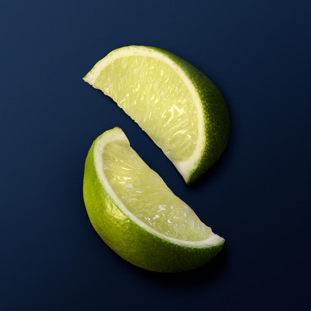 Zwei grune Limettenscheiben auf einem dunklen Hintergrund. Frisch und saftig, bereit zum Verzehr oder zur Verwendung.