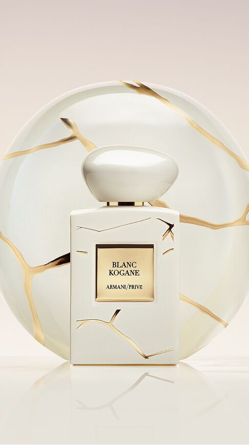 Armani/Prive Blanc Kogane: ein reinweißer Flakon mit Goldmarmorierung vor einem Kintsugi-Porzellanteller, der heitere Weiblichkeit und die sonnige Ausstrahlung von weißem Jasmin und Lilien symbolisiert.