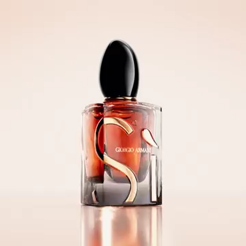A video showcasing the Giorgio Armani Si perfume. It features close-up shots of the amber-colored bottle with its distinctive 'Si' design, alongside key ingredients like vanilla pods, blackcurrants, and a red rose, highlighting the fragrance's composition.