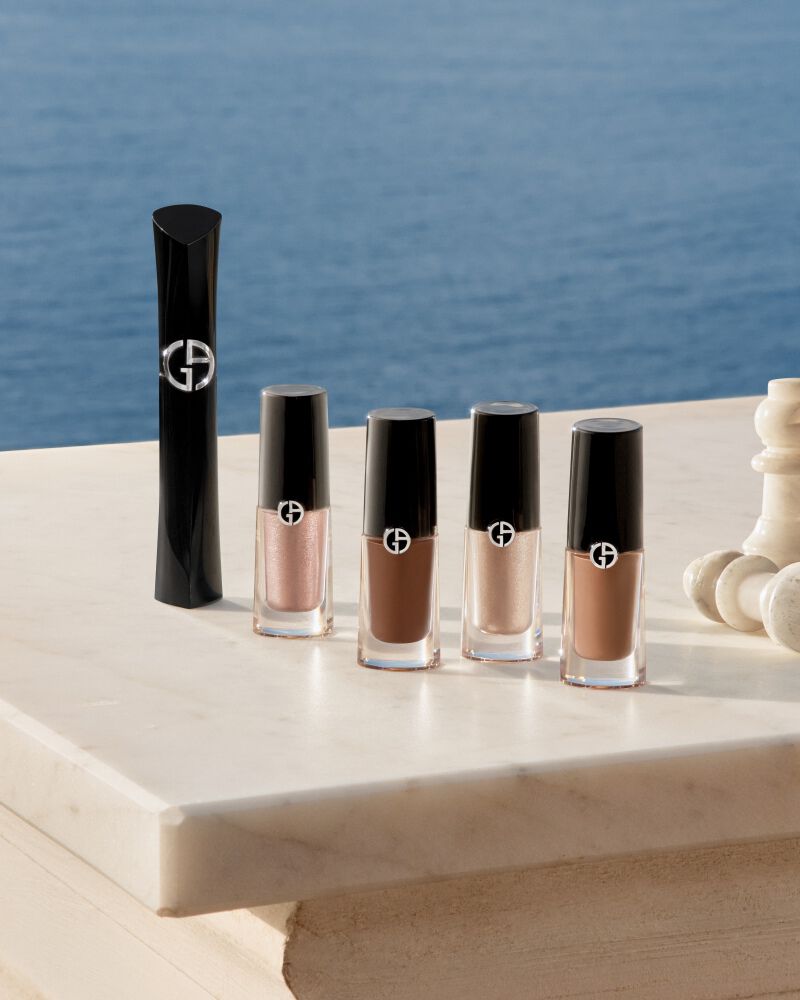 Armani Augen-Essentials: Mascara und Eye Tints mit Schachfiguren auf Marmor vor dem Meer. Ein Symbol fur strategische Schonheit und muhelose sommerliche Eleganz fur eine strahlende Ausstrahlung des Hauses.
