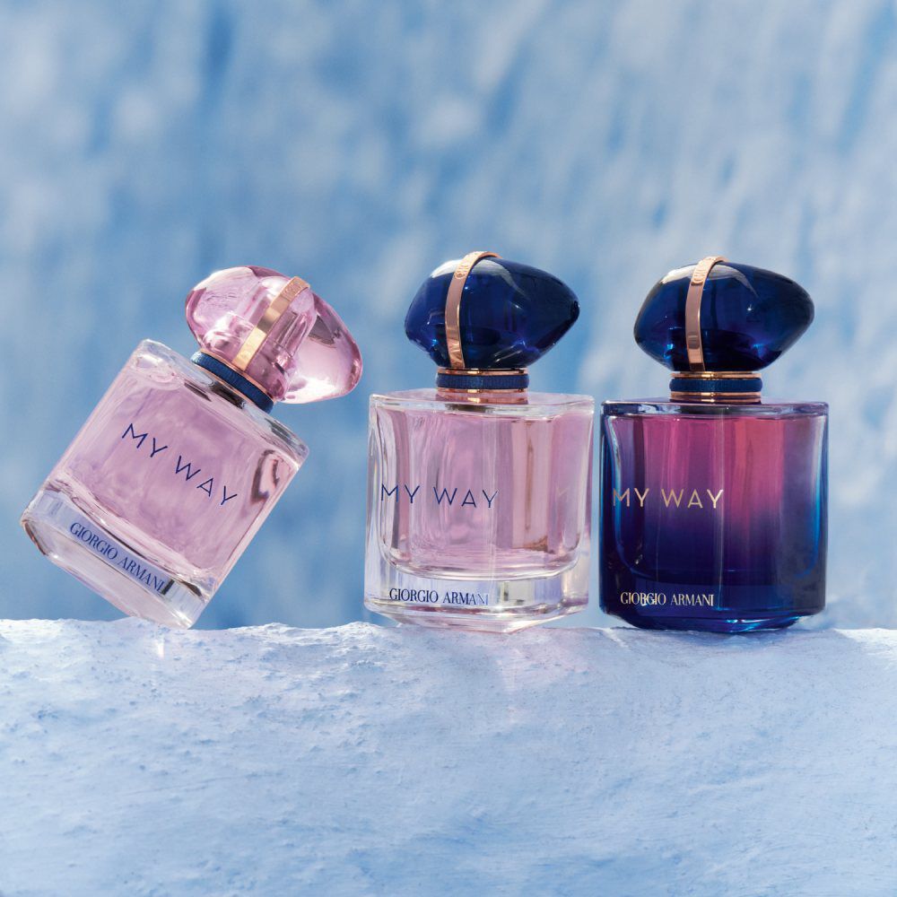 Three elegant perfume bottles labeled "MY WAY" by Giorgio Armani, featuring varying shades of pink and blue, set against a soft, icy background.