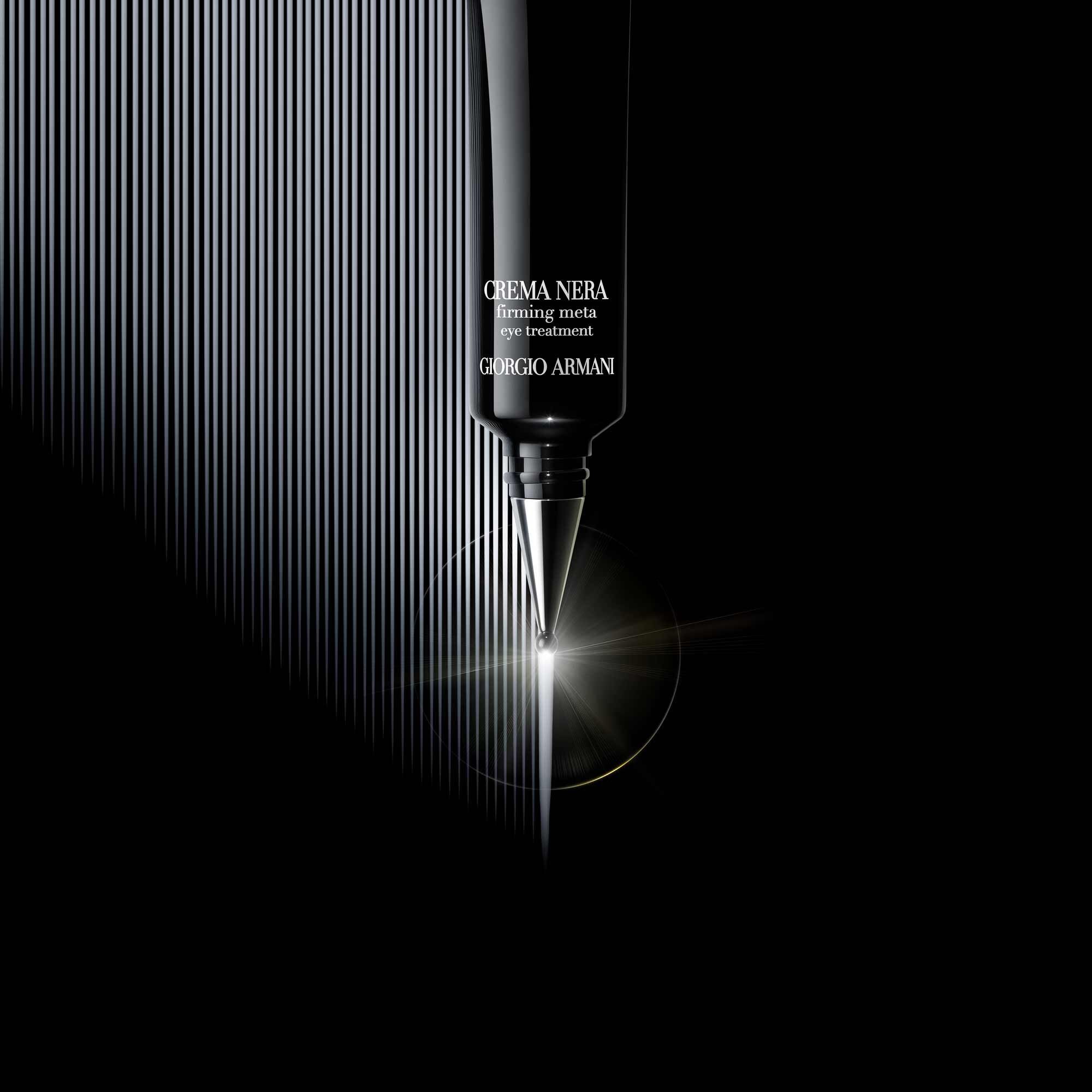 A close-up of a sleek black tube of Giorgio Armani Crema Nera, with the product name visible on the front, set against a dark background with subtle vertical lines and a soft glow.