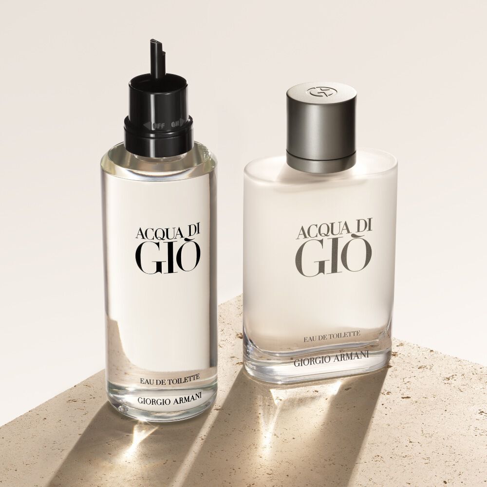 Zwei Flaschen Acqua di Gio Eau de Toilette, die Nachfullung links, werden auf einem beigen, strukturierten Hintergrund prasentiert.