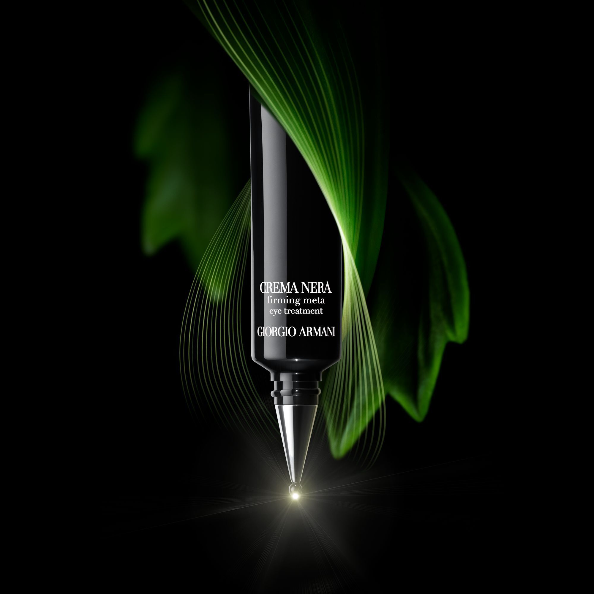 A close-up of a sleek black tube of "Crema Nera" firming eye treatment by Giorgio Armani, with a soft green light and subtle leaf-like elements in the background.