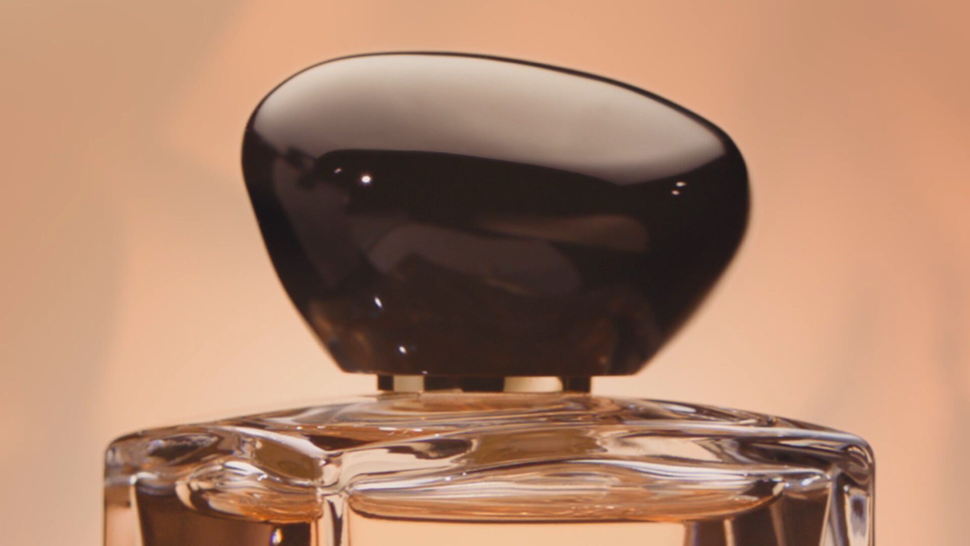 Armani/Prive: elegant close-up of the sculptural black cap and faceted glass bottle, showcasing the fragrance’s refined and contemporary design.