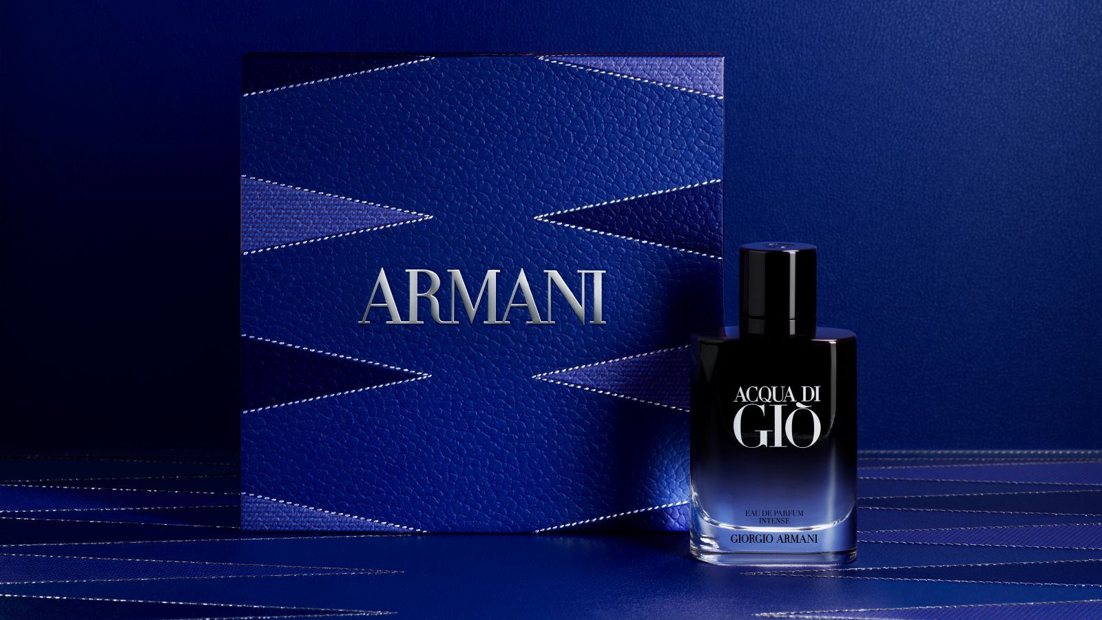 Parfumflakon Giorgio Armani „Acqua di Gio“ mit einer texturierten blauen Armani-Geschenkbox.
