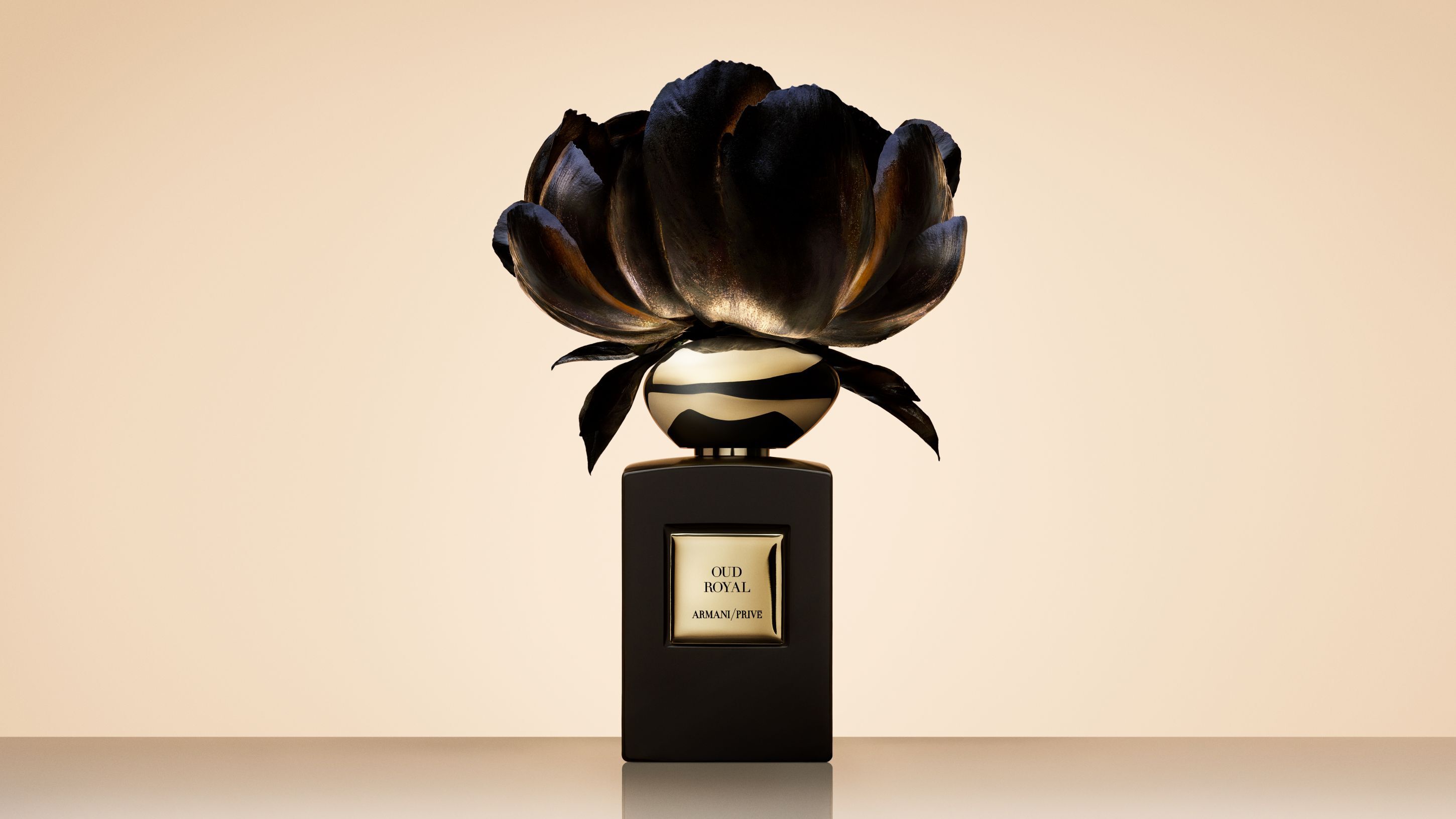 Armani/Prive Oud Royal Parfumflakon, gekront von einer großen, kunstlerischen schwarzen Blume.