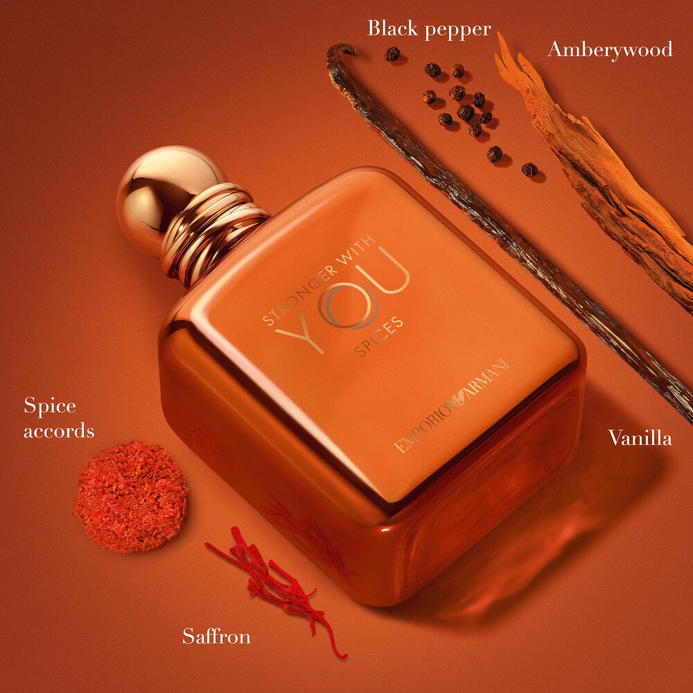 Ein Arrangement aus Vanilleschote, Safran, Gewurzakkord und Kastanie auf einem orangefarbenen Hintergrund, das die komplexen, warmen Noten von ARMANI STRONGER WITH YOU SPICES veranschaulicht.
