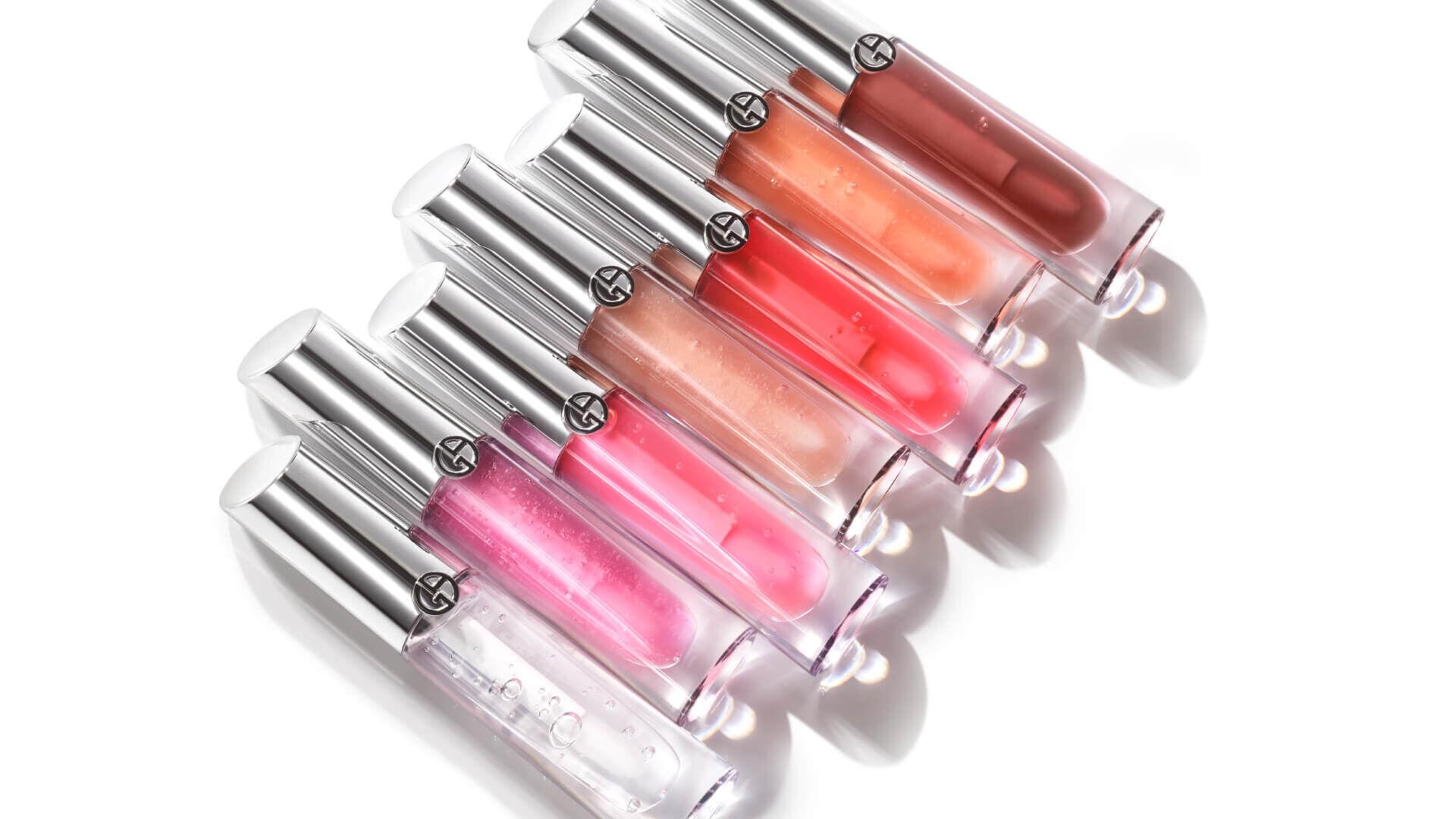 Eine Reihe von sechs Lipgloss-Fläschchen in verschiedenen Farben auf weißem Hintergrund.
