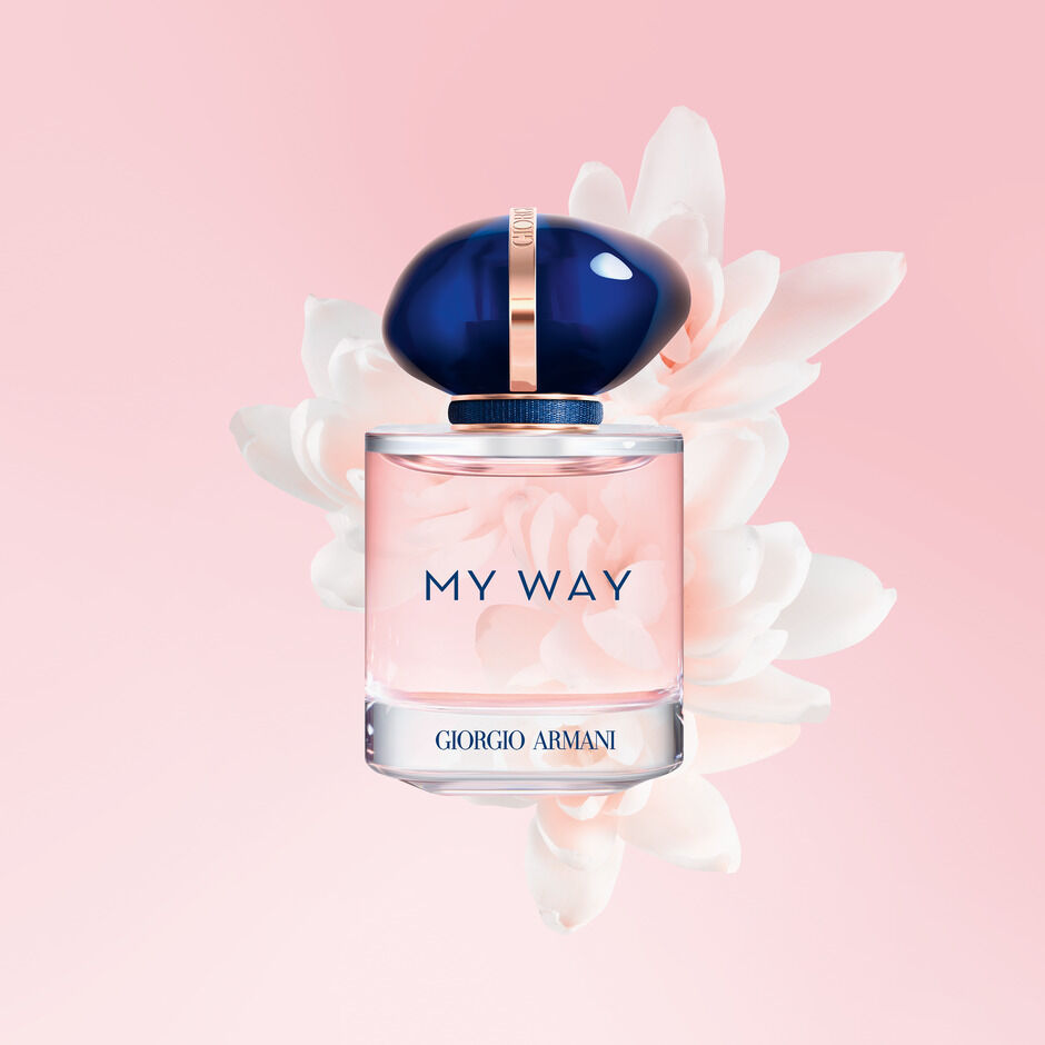 Flasche des Parfums 'My Way' von Giorgio Armani, umgeben von einer zarten Blüte auf einem rosafarbigen Hintergrund.