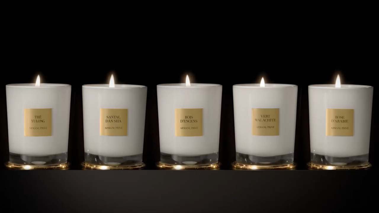 Fünf aromatische Kerzen in eleganten Gläsern, jede mit einzigartigem Duftnamen, vor schwarzem Hintergrund.
